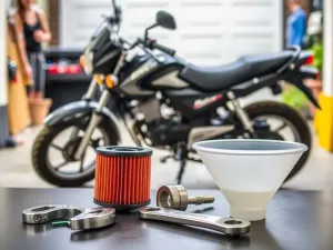 Mechanik podłącza kable rozruchowe do akumulatora w samochodzie, który nie chce odpalić.